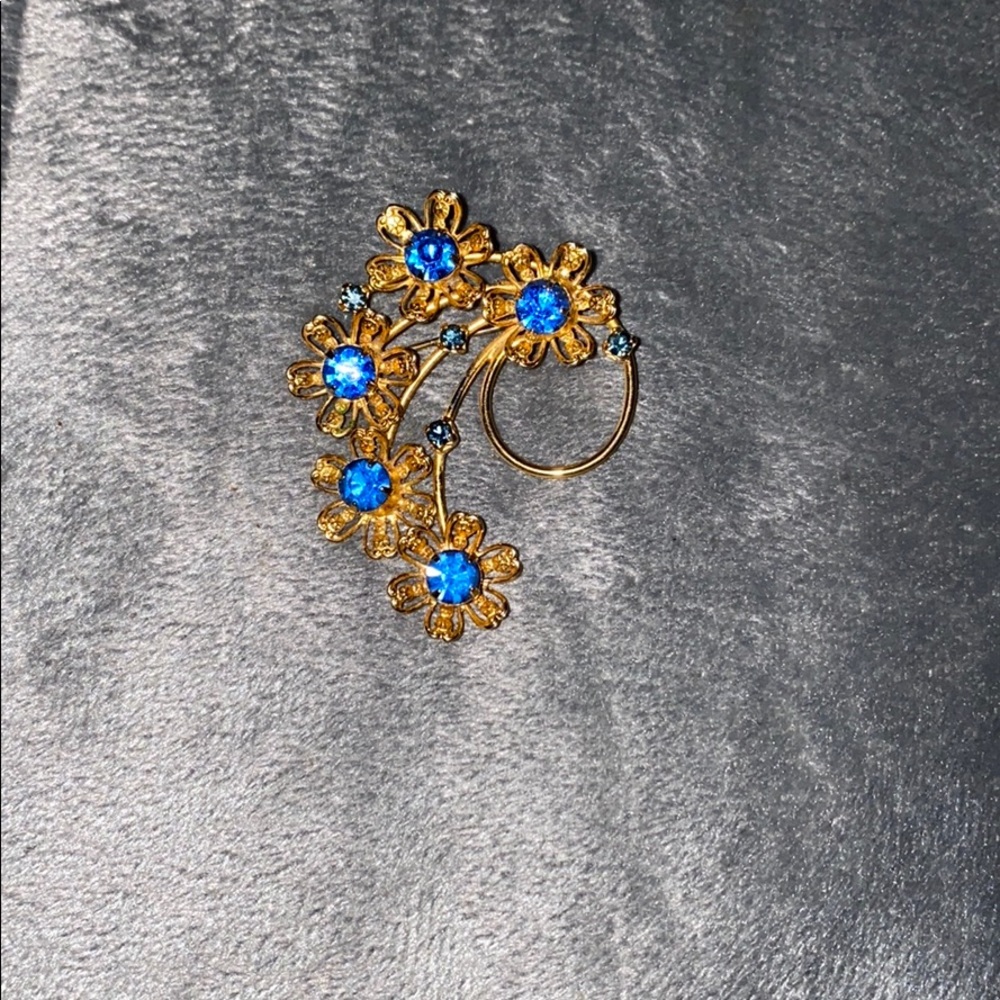 Gold toned pin with blue flowers